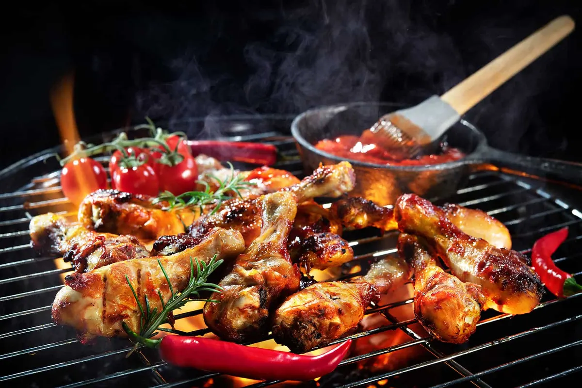 Food being basted on a flaming grill