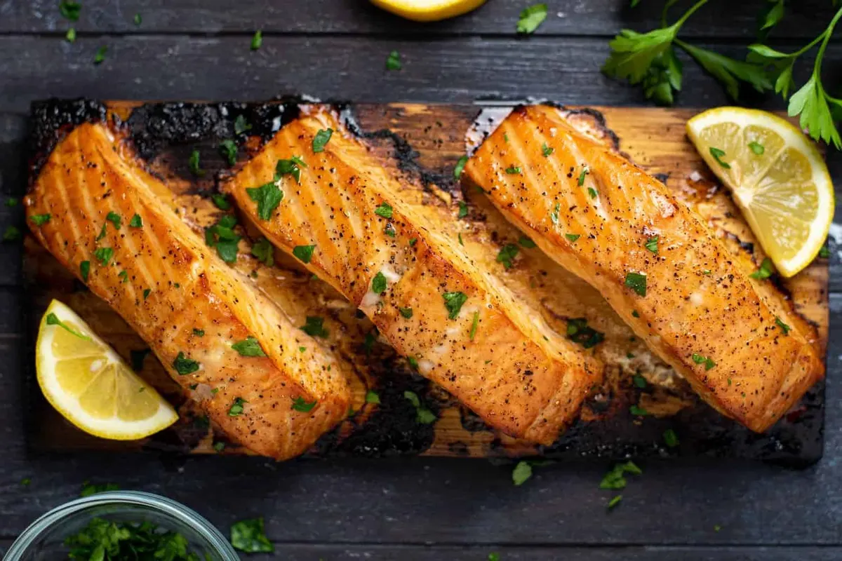 Salmon fillet cooking on a cedar plank